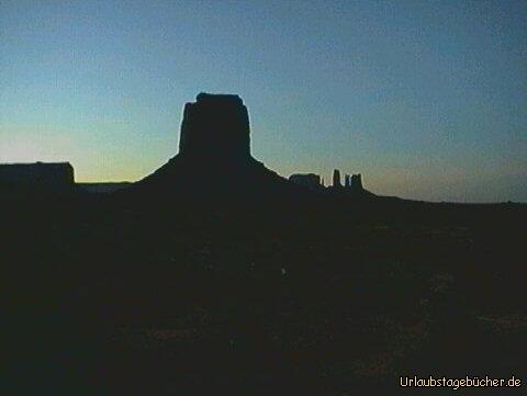 Sonnenuntergang: die Sonne verschwindet hinter den gigantischen Steinformationen des Monument Valley