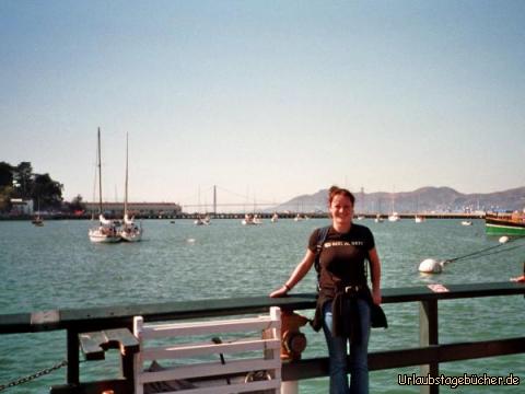 Anja vor der Golden Gate Bridge: Anja am Aquatic Park und weit hinter ihr die Golden Gate Bridge