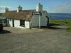 Last House: ich sitze hier neben dem Last House, dem letzten Haus Großbritanniens,
direkt neben dem Fähranleger von John o' Groats zu den Orkney Inseln (hinter mir)